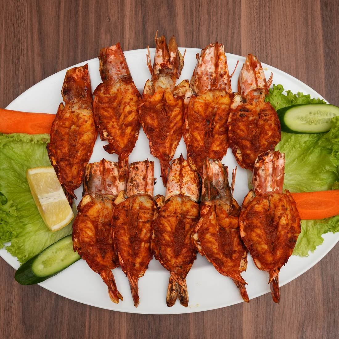 Platter of grilled skewers with salad and lemon, overhead